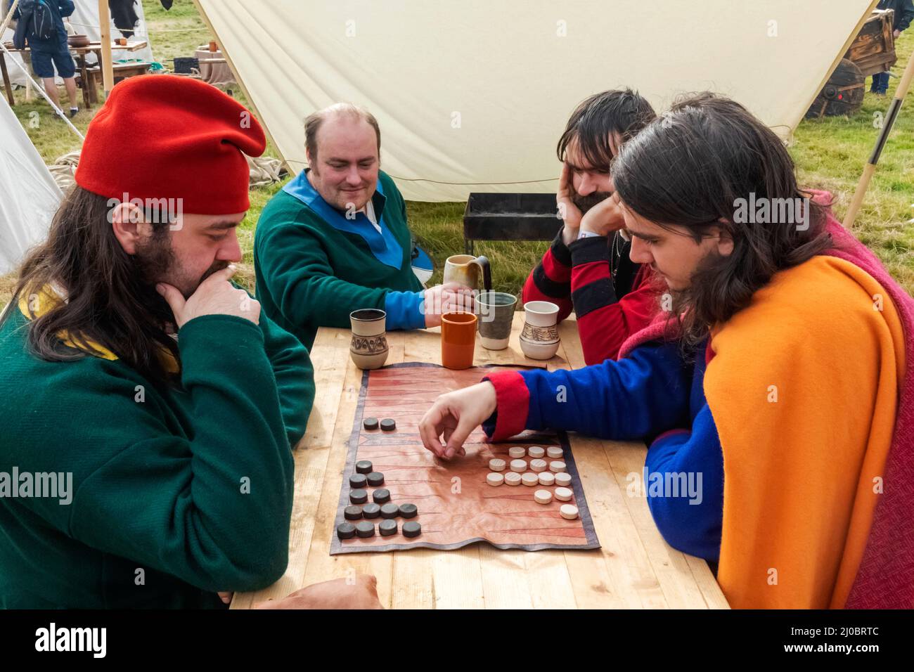 England, East Sussex, Battle, The Annual Battle of Hastings 1066 Re-enactment Festival, Teilnehmer in mittelalterlichen Kostümen, die Backgammon spielen Stockfoto