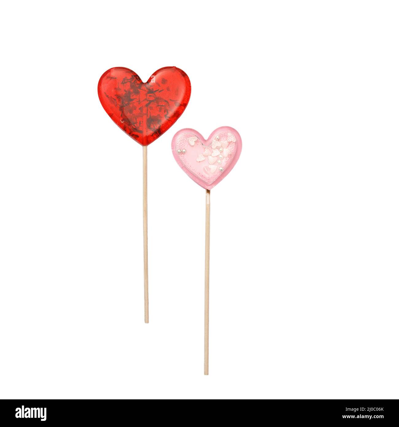 Roter herzförmiger Lollipop mit Kräutern und rosa Stern Lollipop innen auf einem Stock isoliert auf weiß. Geschenk zum Valentinstag. Quadratisches Format Stockfoto