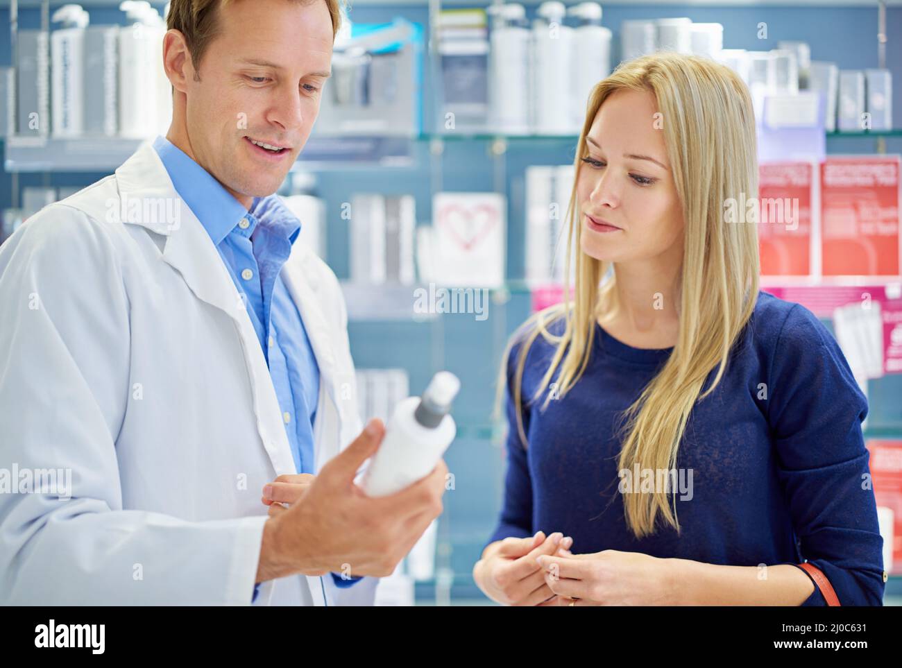 Dies ist das beste Produkt, das wir haben. Aufnahme eines Arztes und Kunden, der in einem Kosmetikgeschäft steht. Stockfoto