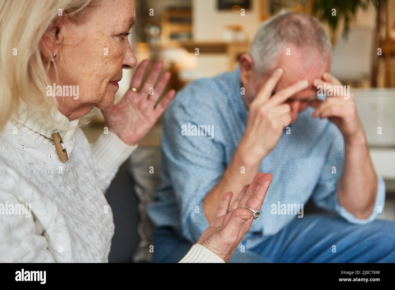 Ältere Paare, die zu Hause einen Streit mit einem frustrierten Mann und einer aggressiven älteren Frau haben Stockfoto