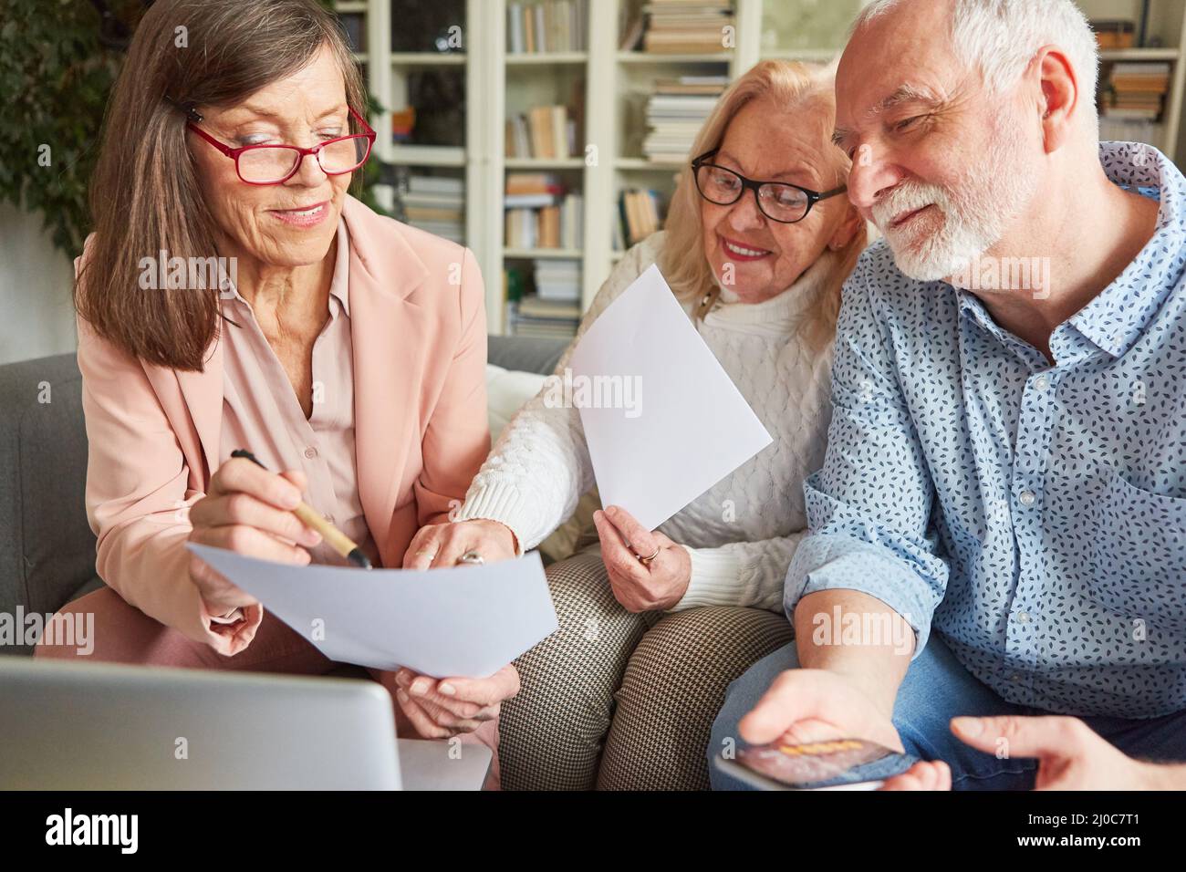 Buchhalter und Senior-Paar in einer Beratung mit einem Formular für langfristige Pflegeversicherung Stockfoto
