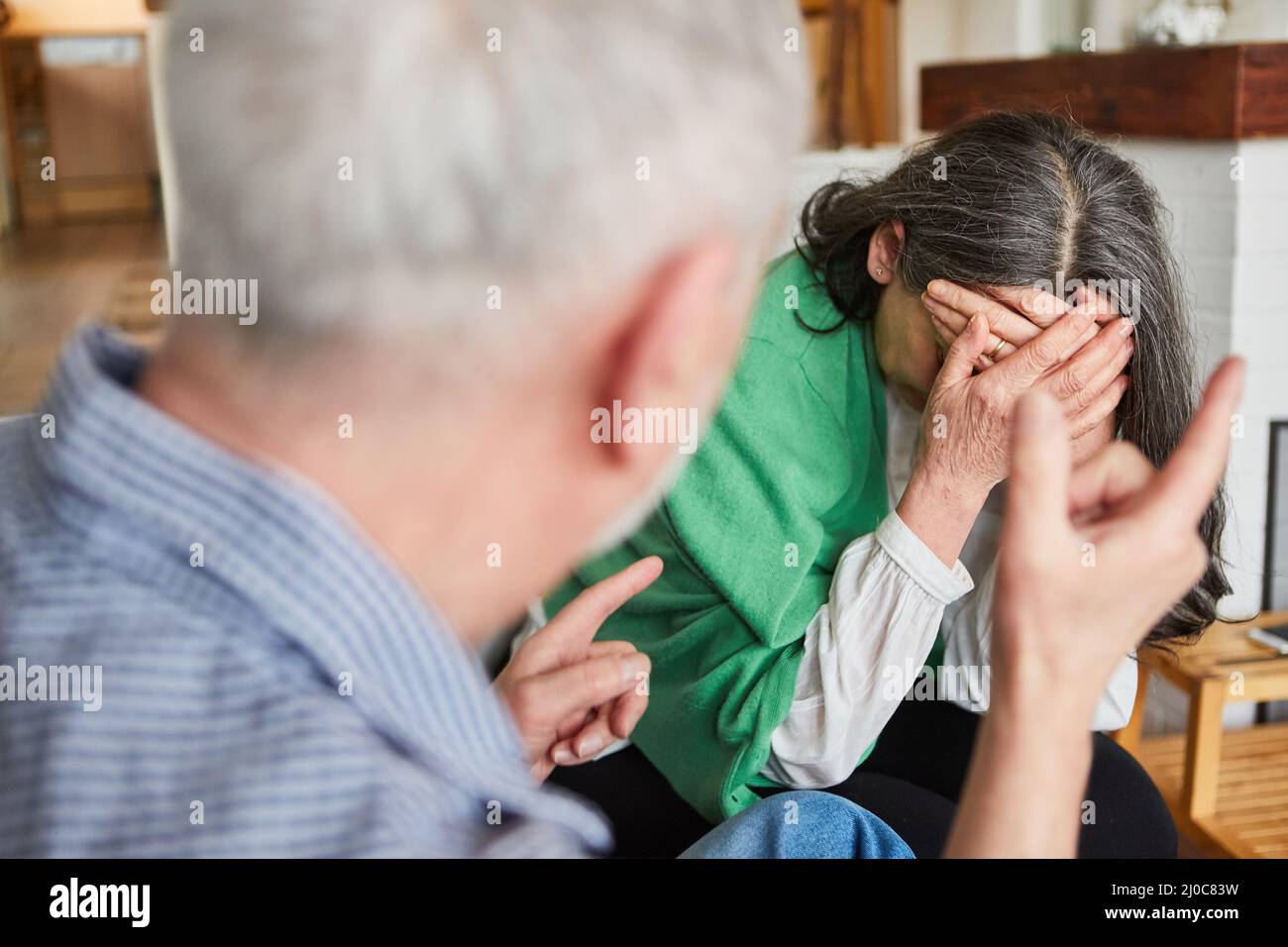 Häusliche Gewalt bei Senioren in Pflege mit weinenden Frau und aggressiven Senior Stockfoto