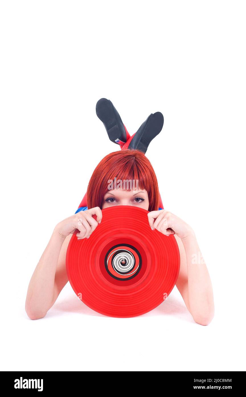 Das Disco-Mädchen versteckte ihr Gesicht hinter der roten Schallplatte in ihren Händen Stockfoto