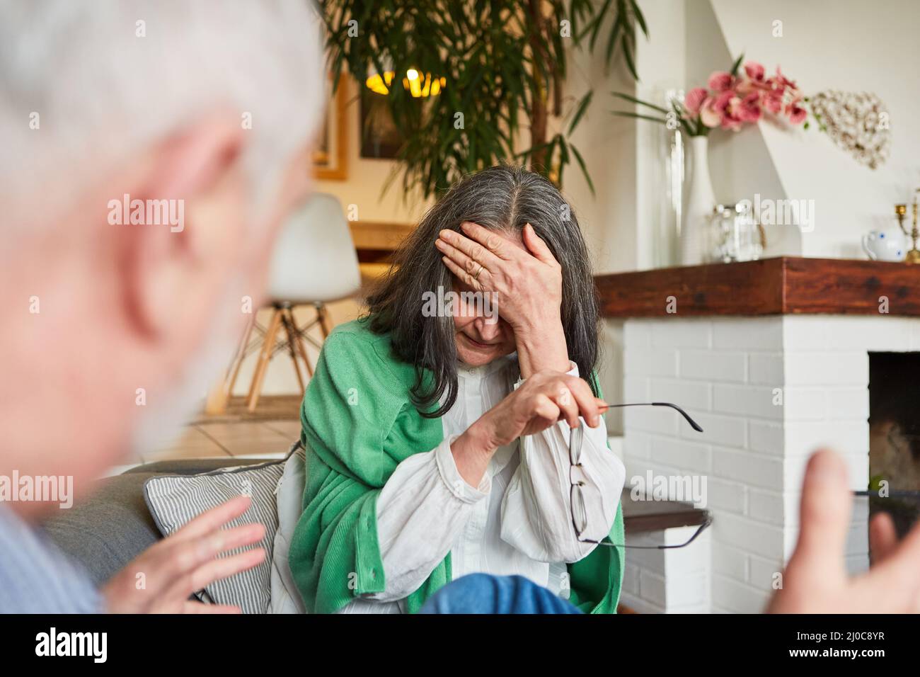 Ältere Paare streiten sich im Wohnzimmer als Symbol für Eifersucht oder Beziehungskonflikte Stockfoto