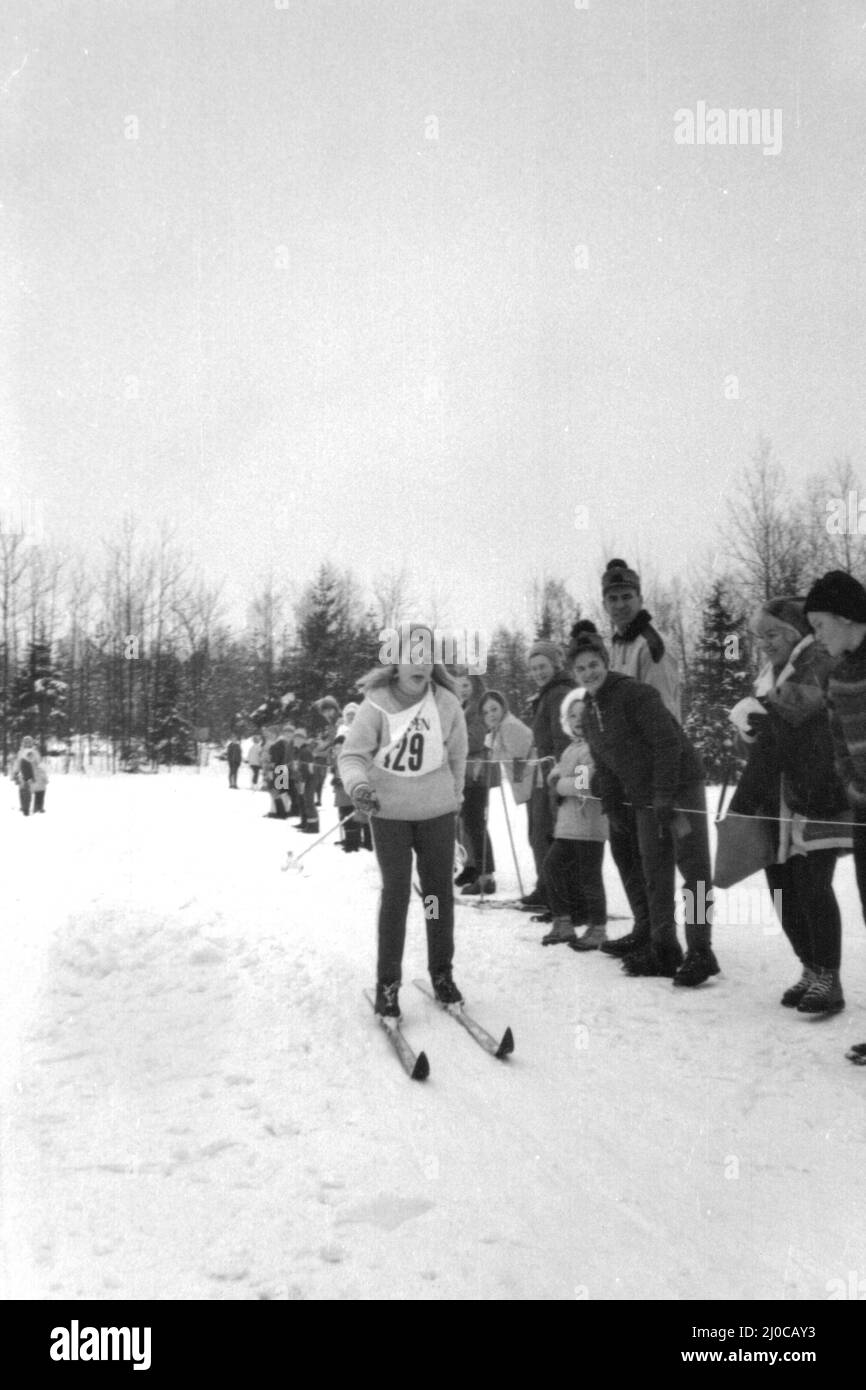 60iger Jahre authentisches Vintage-Foto von einer jungen Frau, die von Zuschauern beim Skifahren beobachtet wurde, Schweden. Konzept des Wettbewerbs Stockfoto
