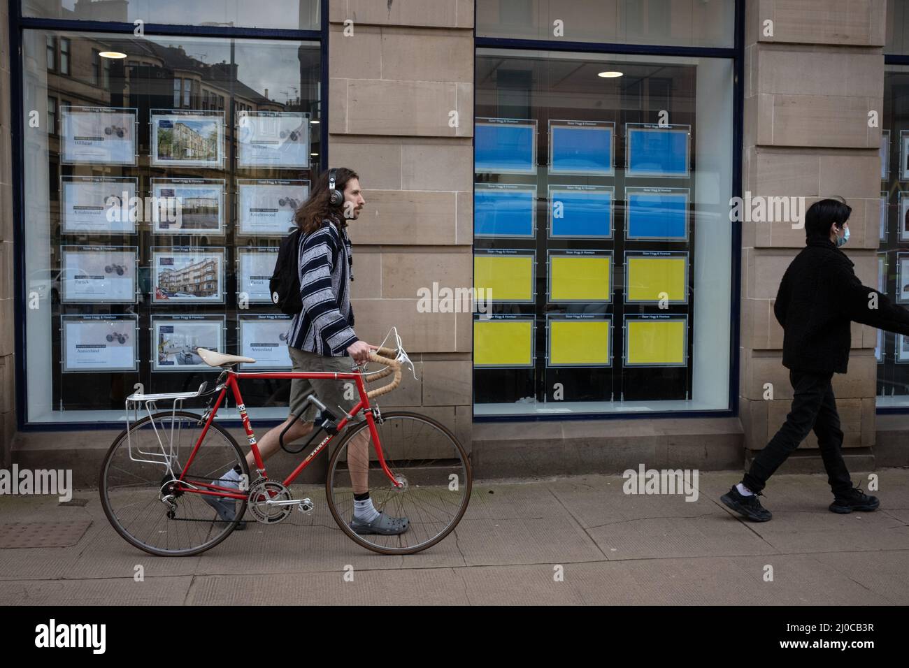 Glasgow, Großbritannien. 18. März 2022. Immobilienmakler im cityÕs West End zeigen ihre Unterstützung für die Ukraine, die von Russland eingedrungen ist, indem sie ukrainische Flaggen in ihren Fenstern anstelle von Hauslisten in Glasgow, Großbritannien, zeigen. 18. März 2022. Foto: Jeremy Sutton-Hibbert/Alamy Live News. Stockfoto