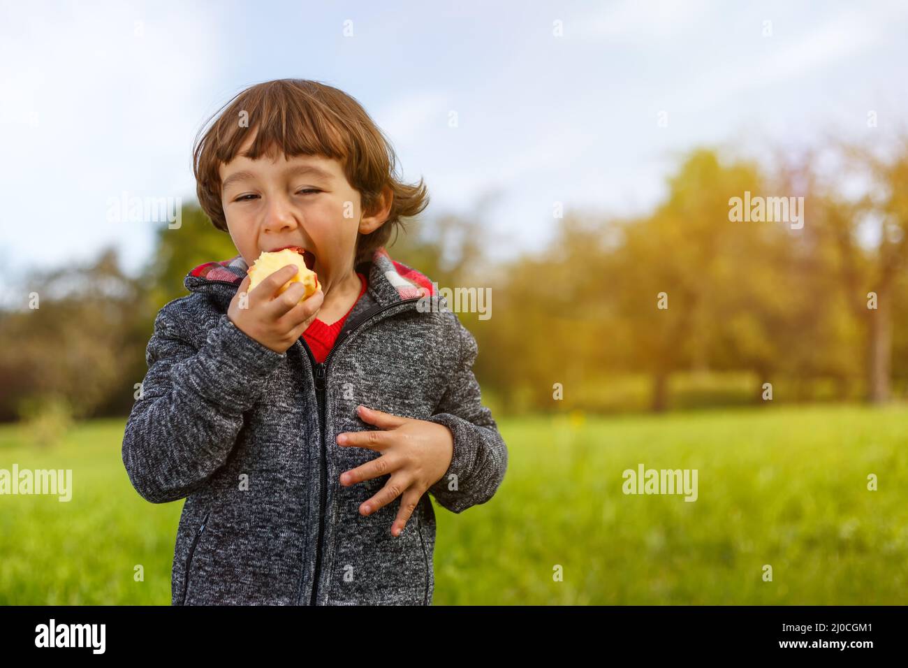 Kind Apfel Obst Früchte essen außerhalb Herbst Natur gesunde Ernährung Text freien Raum Stockfoto