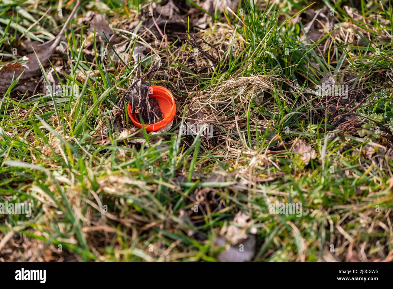 Eine Plastikkappe ist Verschmutzung in einer Wiese Stockfoto