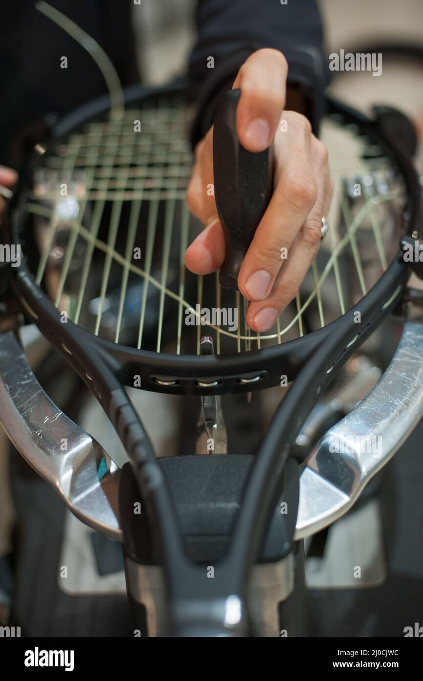 Stringing Machine. Detail der Tennis Stringer Hände beim Halten Ahle