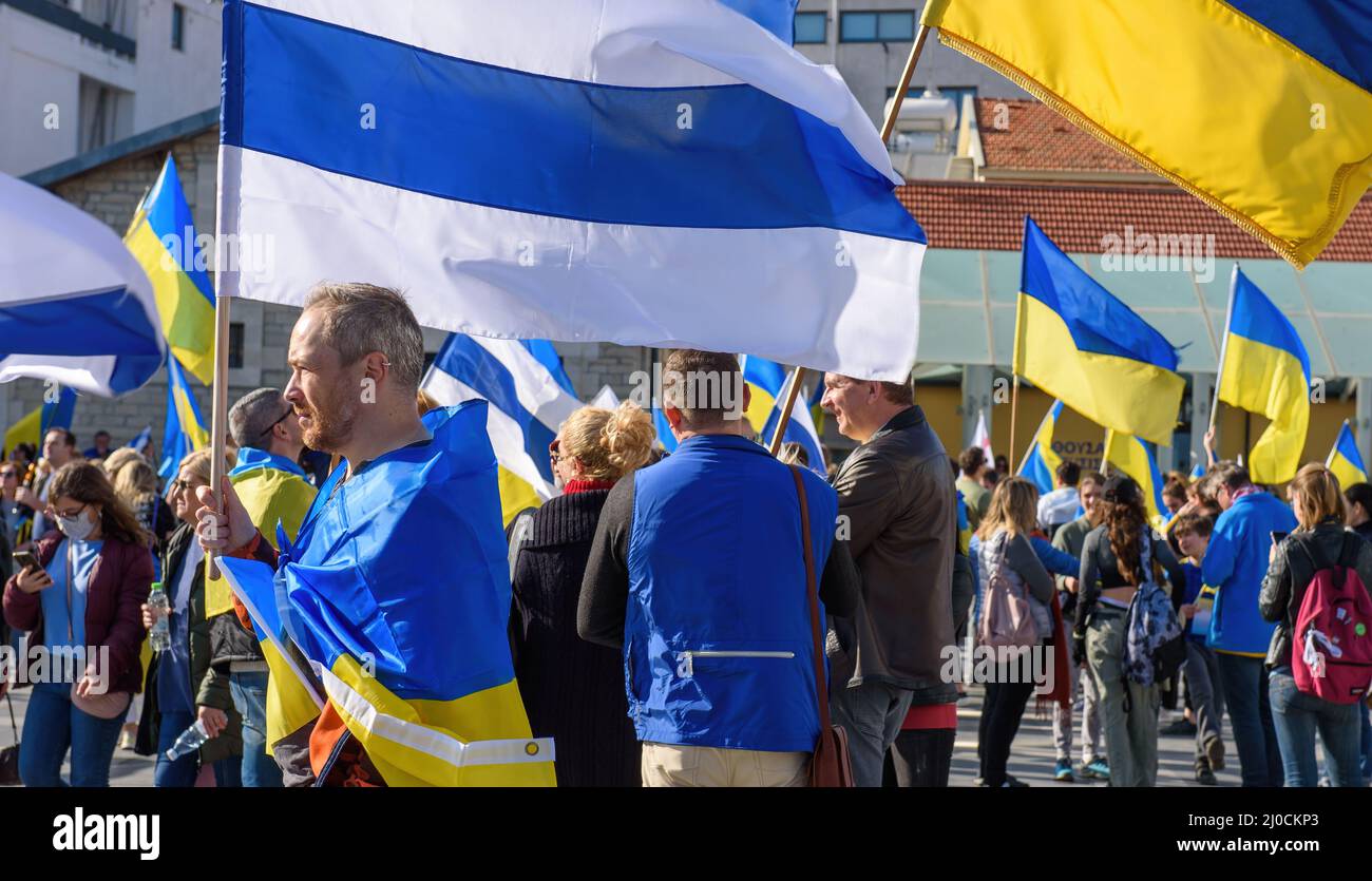 LIMASSOL, ZYPERN - 5. MÄRZ 2022: Mann mit weißer, blauer weißer Anti-Kriegs-Flagge auf einer Kundgebung zur Unterstützung der Ukraine Stockfoto