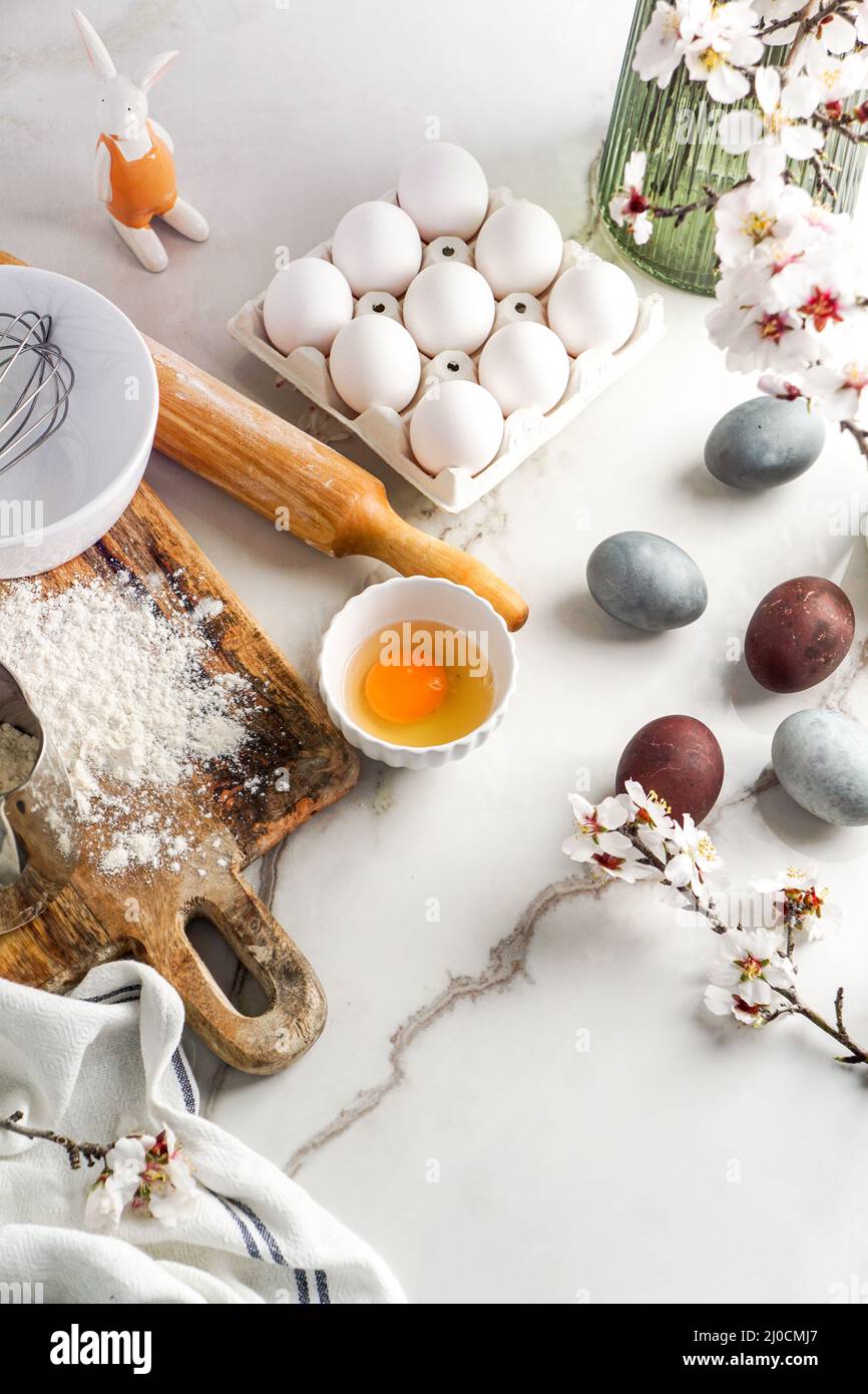 Kulinarischer Hintergrund zu Ostern. Zutaten für Ostern auf dem Küchentisch und Platz für ein Textmenü oder Rezept Stockfoto