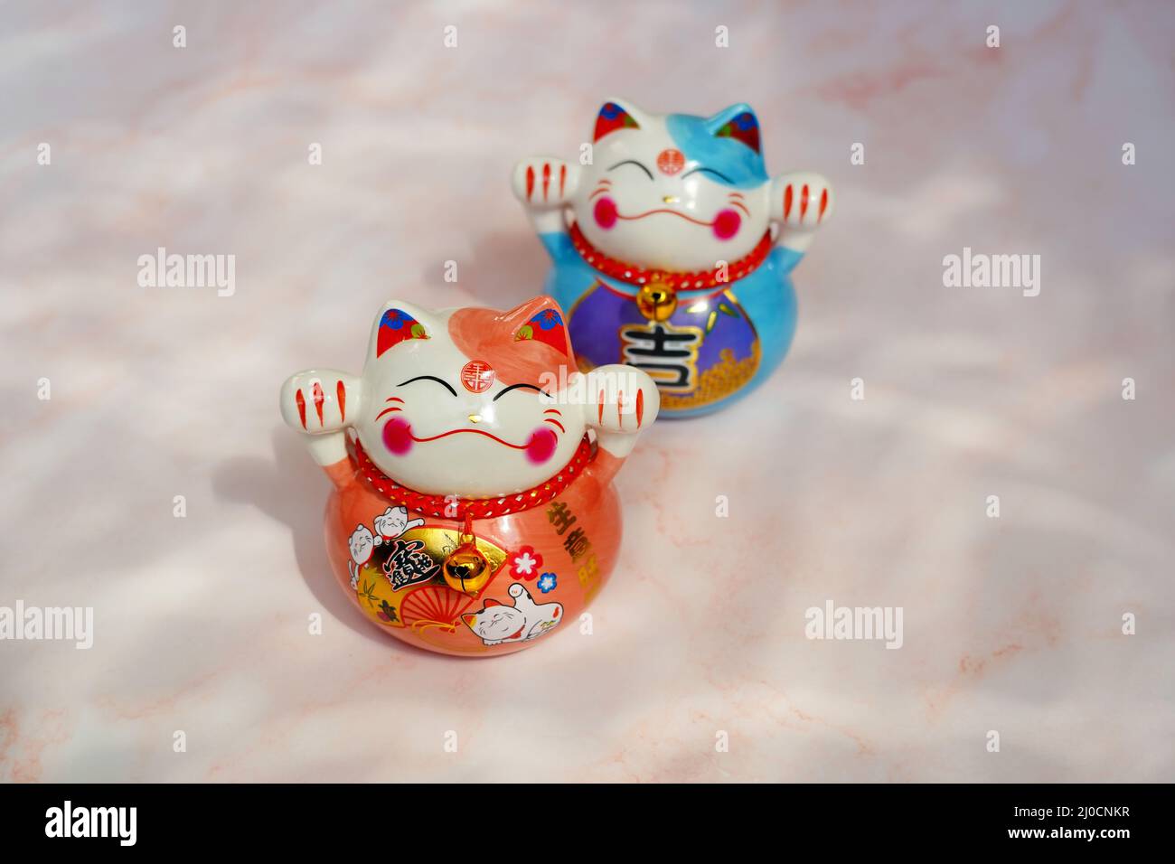 Japanische winkende Katzen (Maneki neko) aus Porzellan. Sie sind traditionelle Symbole des Glücks. Stockfoto