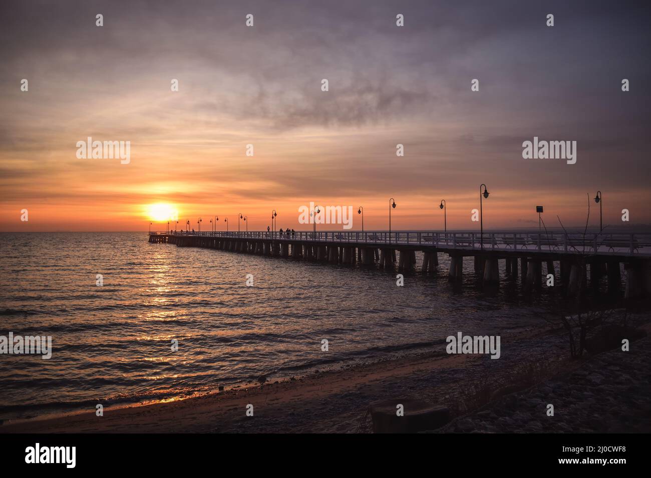 Farbenfrohe Morgenlandschaft am Meer. Hölzerner Pier am Meer bei Sonnenaufgang. Stockfoto