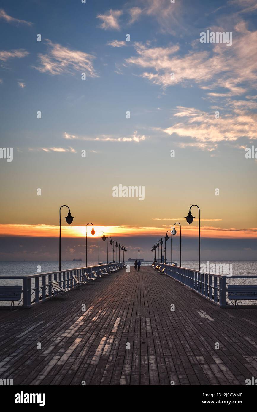 Wunderschöne Landschaft am Morgen am Meer. Hölzerner Pier mit einem bunten Himmel in Gdynia Orlowo, Polen. Stockfoto