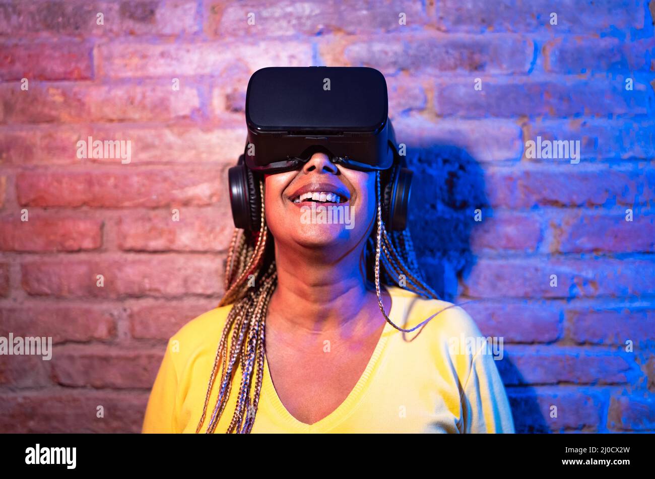 Ältere afrikanische Frau mit Spaß spielen mit innovativen Virtual-Reality-Brille - Tech-Gaming-Entertainment-Konzept Stockfoto