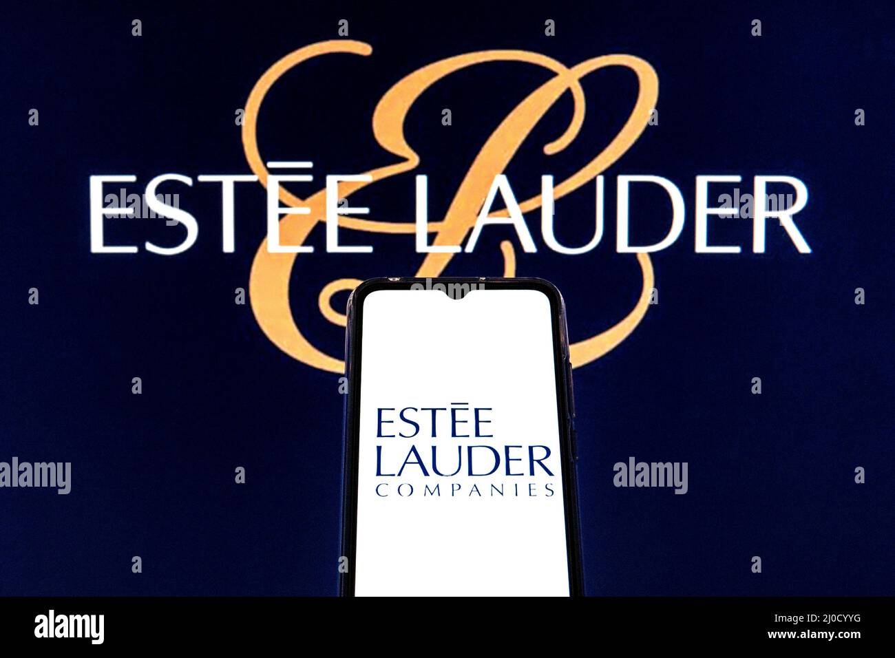 In dieser Abbildung ist das Logo von Estee Lauder Companies Inc. Auf einem Smartphone mit dem Logo von Estee Lauder Companies Inc. Im Hintergrund zu sehen. Stockfoto