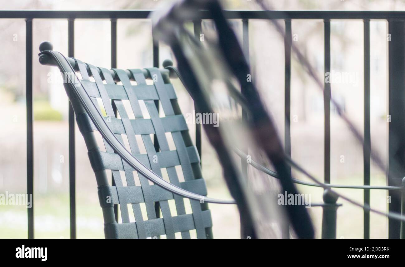 Schwarze Plastikstühle im Freien geben durch die Bildschirmtür eine Atmosphäre ab Stockfoto