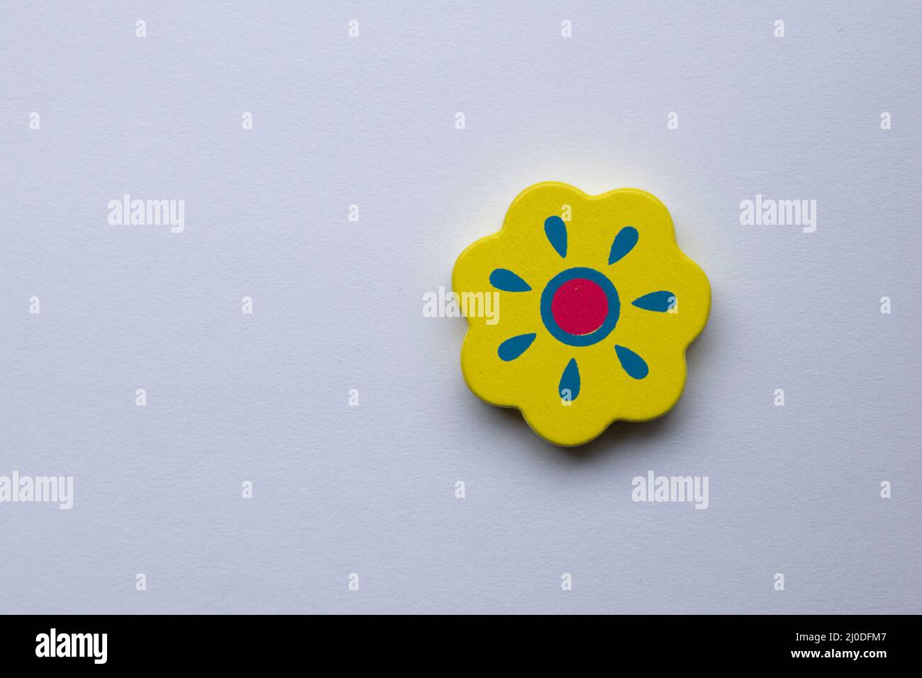 Stillleben Sonnenblume auf farbigem Hintergrund. Geschnitzte Holzblume. Speicherplatz kopieren Stockfoto