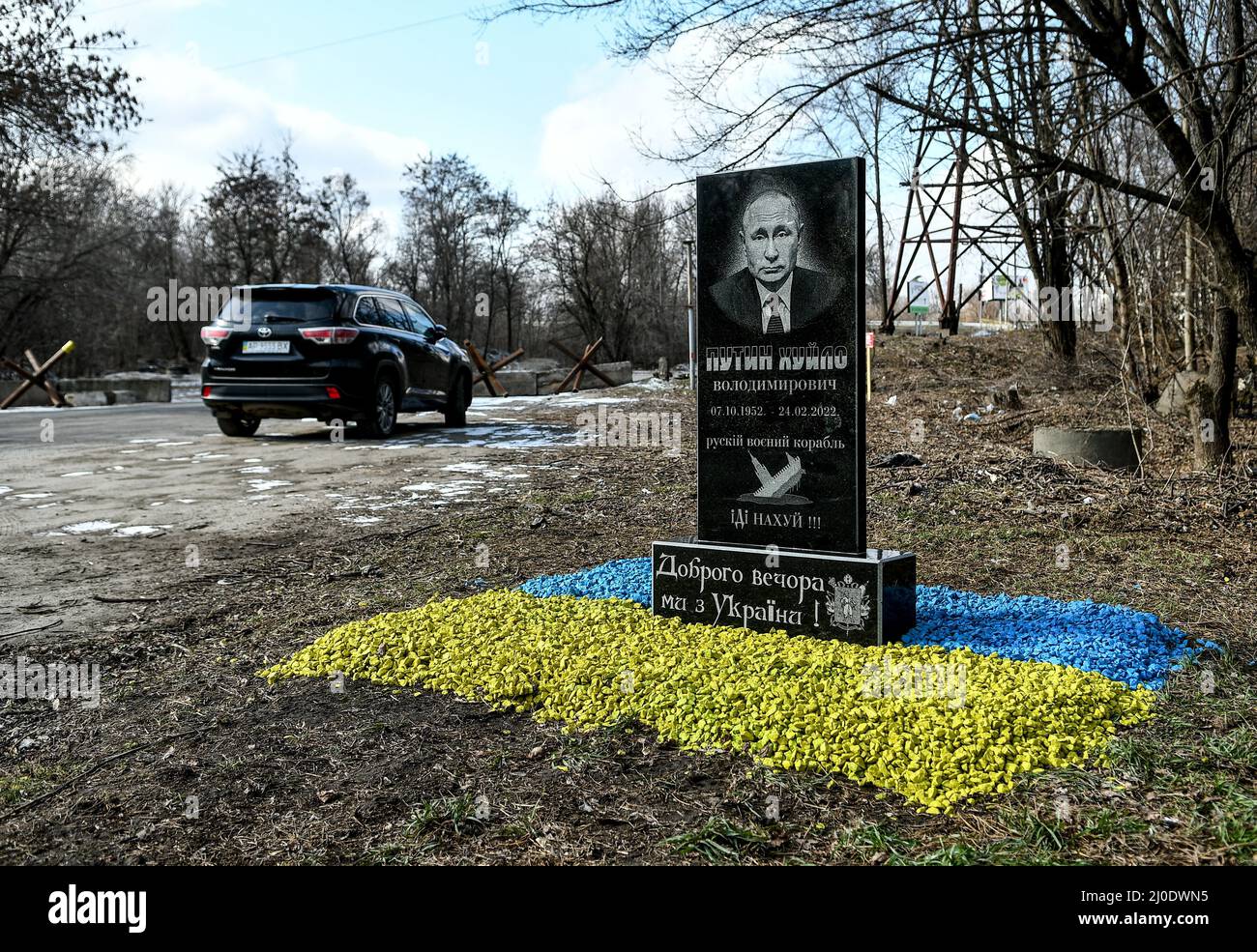 SAPORISCHSCHSCHJA, UKRAINE - 18. MÄRZ 2022 - der von einer Gruppe lokaler Aktivisten eingesetzte Grabstein des russischen Präsidenten Wladimir Putin steht auf dem Bett Stockfoto