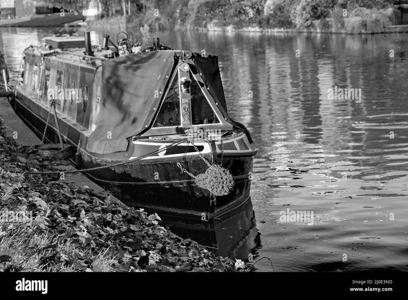 Schwarz-Weiß-Bild eines traditionellen schmalen Bootes, das auf dem River Cam in Jesus Green, Cambridge, festgemacht ist Stockfoto