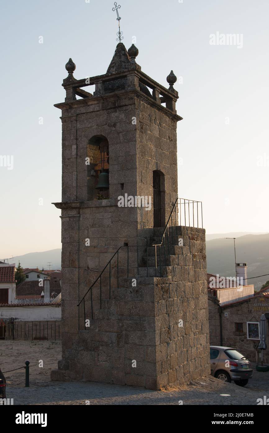 Mittelalterlicher Glockenturm neben der Kirche mit einem schönen Licht. Aus Stein, mit einer Treppe. Belmonte ist eine niedliche kleine Stadt im Osten Portugals, Stockfoto