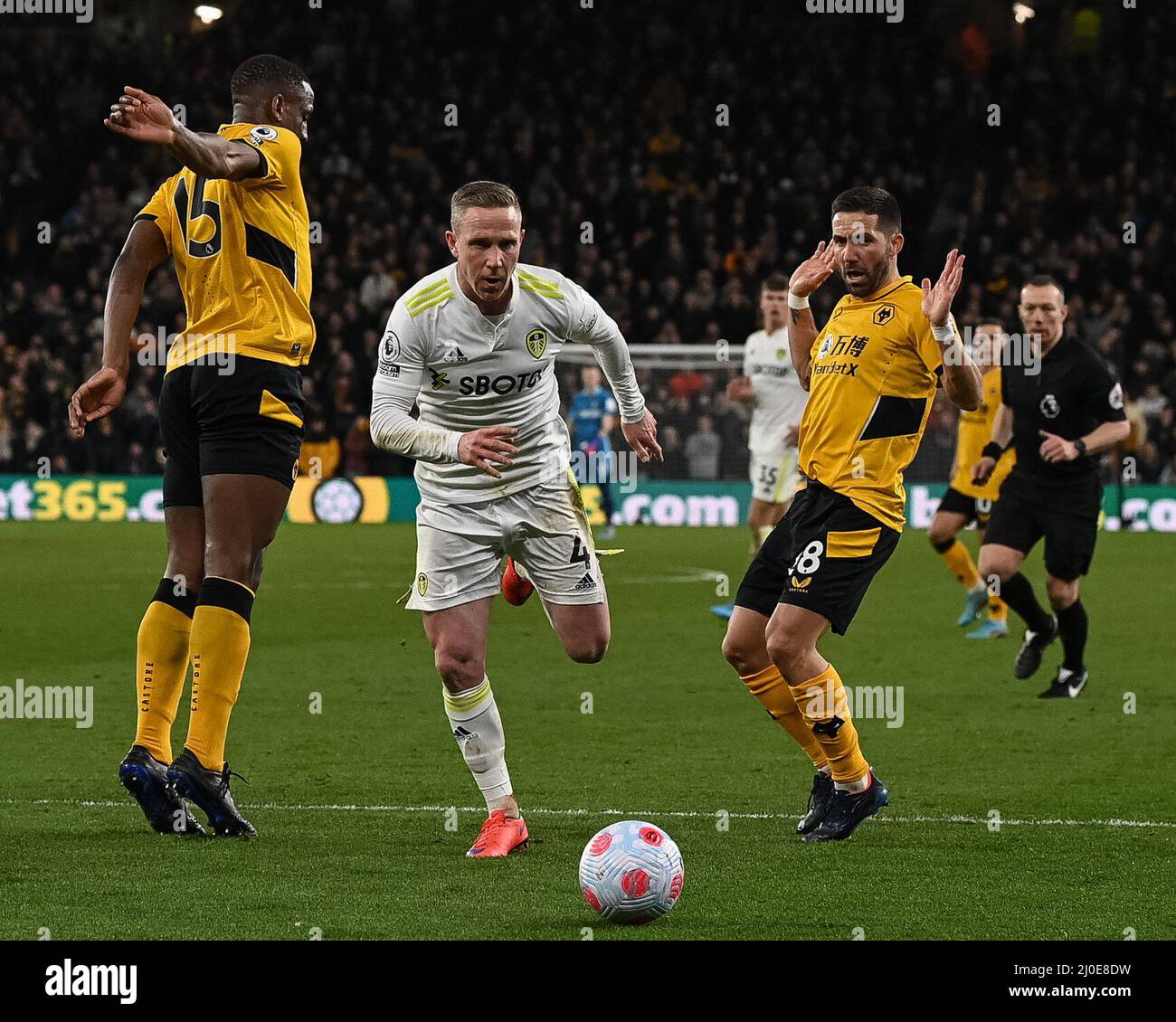 Wolverhampton, Großbritannien. 18. März 2022. Adam Forshaw #4 von Leeds United barges durch Willy Boly #15 von Wolverhampton Wanderers und Joao Moutinfors #28 von Wolverhampton Wanderers in Wolverhampton, Vereinigtes Königreich am 3/18/2022. (Foto von Craig Thomas/News Images/Sipa USA) Quelle: SIPA USA/Alamy Live News Stockfoto