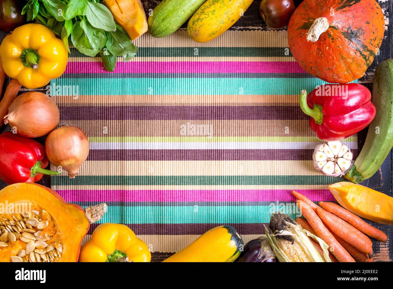 Frisches Gemüse auf einem bunt gestreiften Handtuch für die Küche. Herbst Hintergrund Stockfoto