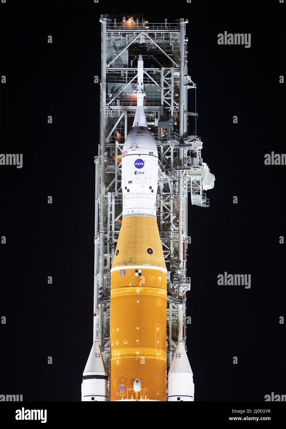 Kennedy Space Center, USA. 18. März 2022. Die NASA Space Launch System Rakete mit der Orion-Sonde an Bord wird von Scheinwerfern auf einem mobilen Trägerrakete am Launch Complex 39B im Kennedy Space Center, 18. März 2022, in Cape Canaveral, Florida, beleuchtet. Die massive Rakete wurde zum ersten Mal vor dem Flugtest der vollständig gestapelten und integrierten SLS-Rakete und des Orion-Raumschiffs auf die Startrampe ausgerollt. Quelle: Joel Kowsky/USA Navy Photo/Alamy Live News Stockfoto