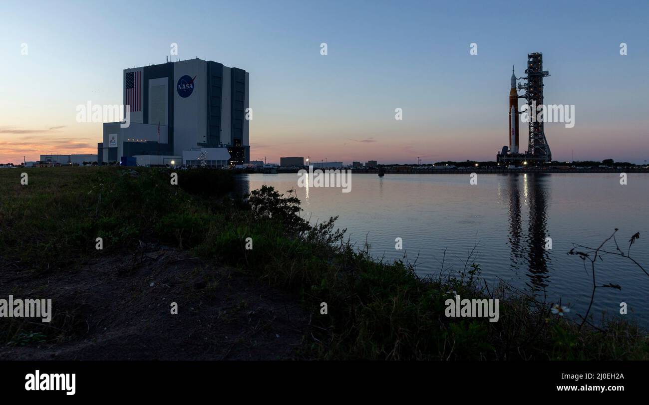 Kennedy Space Center, USA. 17. März 2022. Die NASA Space Launch System Rakete mit der Orion-Sonde an Bord wird auf einem mobilen Trägerrakete im Launch Complex 39B im Kennedy Space Center, 18. März 2022, in Cape Canaveral, Florida, ausgerollt. Die massive Rakete wurde zum ersten Mal vor dem Flugtest der vollständig gestapelten und integrierten SLS-Rakete und des Orion-Raumschiffs auf die Startrampe ausgerollt. Kredit: Keegan Barber/U.S. Navy Photo/Alamy Live News Stockfoto