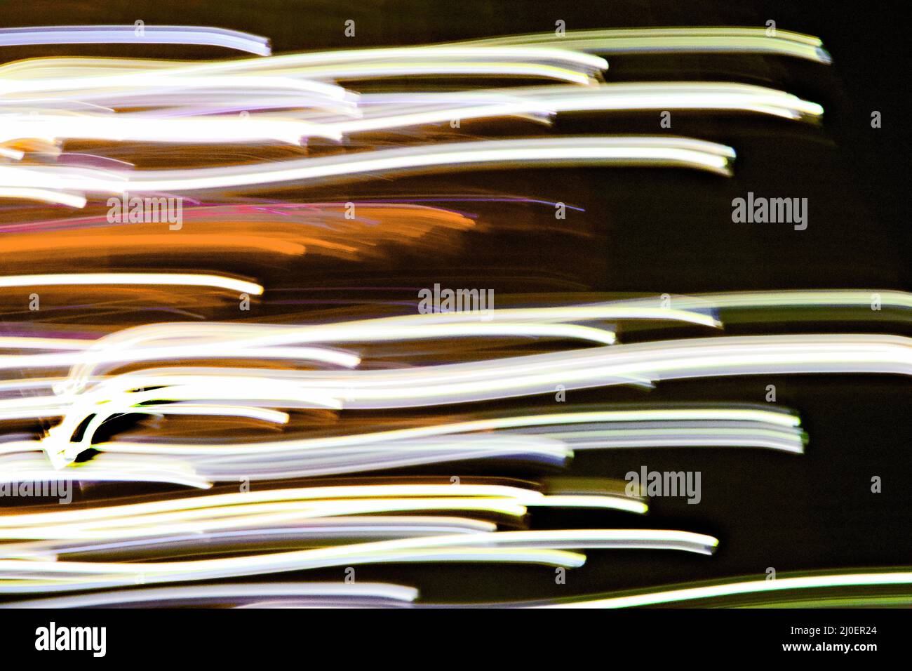 Konzeptuelle grafische Lichtstreifen, die Geschwindigkeit und fotografische Experimente anzeigen. Stockfoto