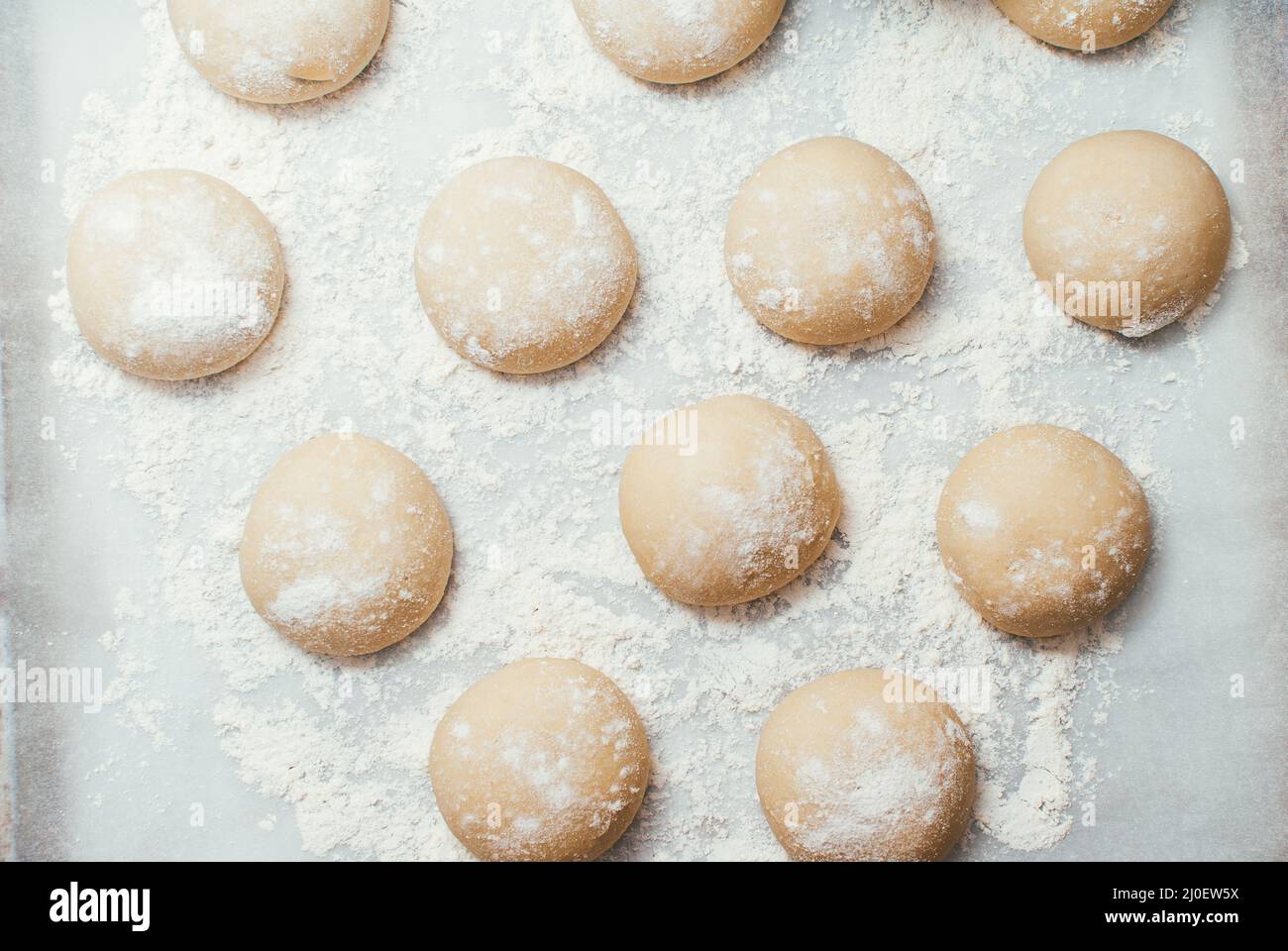 Hausgemachte Teigpasteten auf dem Backblech bereit für den Backofen zum Backen. Makroaufnahme mit selektivem Fokus und flachem Freiheitsgrad Stockfoto