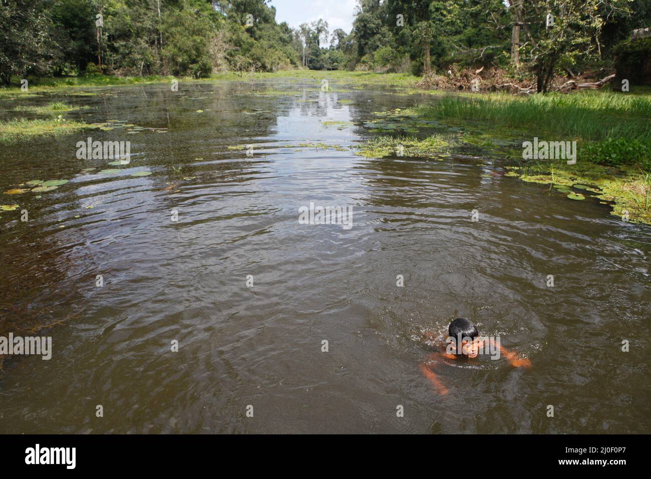 Ein Kind schwimmt auf einem Kanal nordöstlich zum Preah Khan Tempel