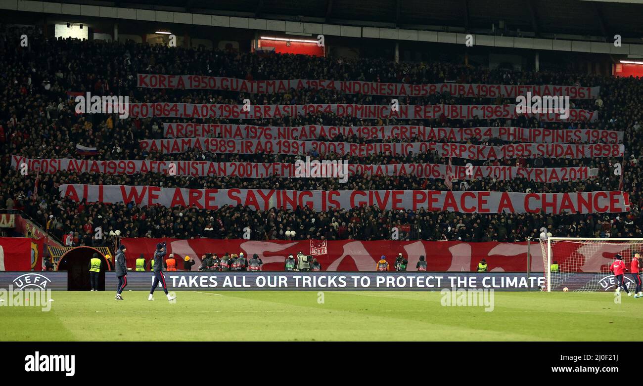 Belgrad, Rajko-Mitic-Stadion in Belgrad. 17. März 2022. Fans des serbischen Fußballvereins Red Star verwenden Banner, um die von den USA geführten NATO-Interventionen in den vergangenen Jahrzehnten weltweit zu zeigen, während der Halbzeit des Spiels im Rajko-Mitic-Stadion in Belgrad, Serbien, am 17. März 2022. Die serbischen Fans hoben riesige Banner auf, auf denen US-geführte NATO-Interventionen in den letzten Jahrzehnten aufgelistet waren, von denen eines über den Anti-Kriegs-Song des Beatles-Songwriters John Lennon schrieb: „Wir sagen nur, dass wir dem Frieden eine Chance geben.“ Kredit: Predrag Milosavljevic/Xinhua/Alamy Live Nachrichten Stockfoto