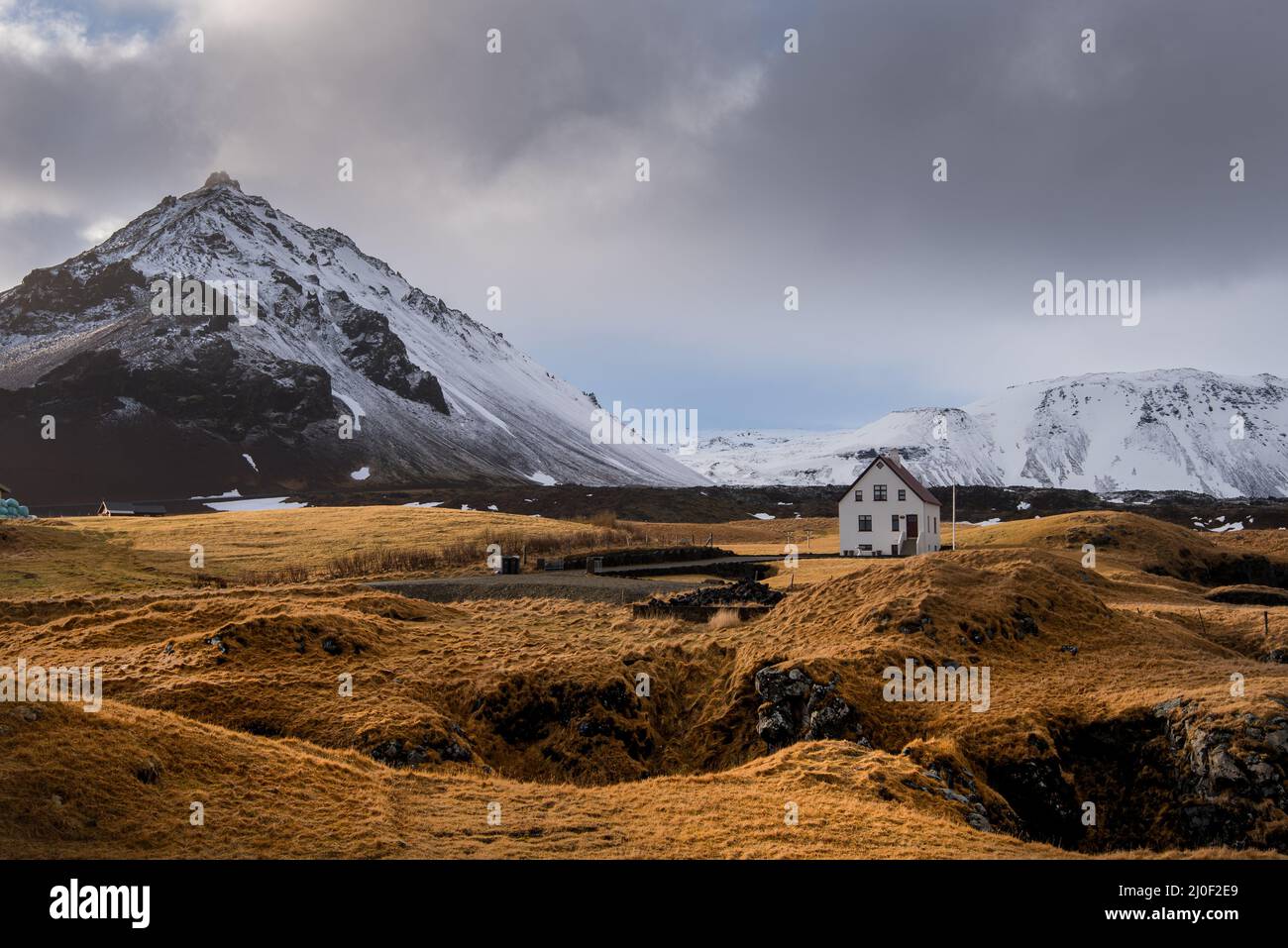 Einsames Haus und Stapafell Berg mit Schnee bedeckt, Arnarstapi, Island Stockfoto