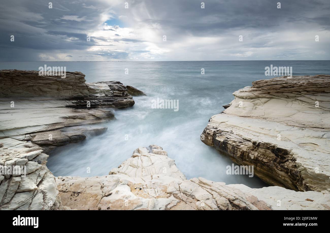 Felsige Küste mit weißen Felsen während des Sonnenuntergangs Lmassol, Zypern Stockfoto