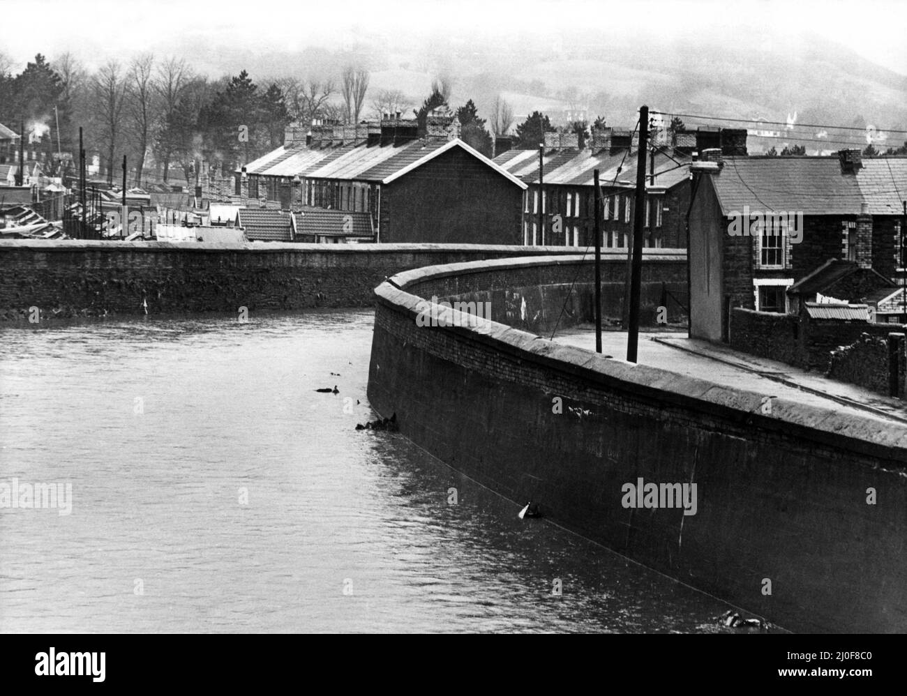 Der Fluss Rhondda bei Gelli. Gelli ist ein Dorf im Rhondda Fawr-Tal, in der Grafschaft Rhondda Cynon Taff, Wales. Der Blick von der Alexander Road, im Hintergrund in einer Kohlespitze abgebildet. 31.. März 1978 Stockfoto