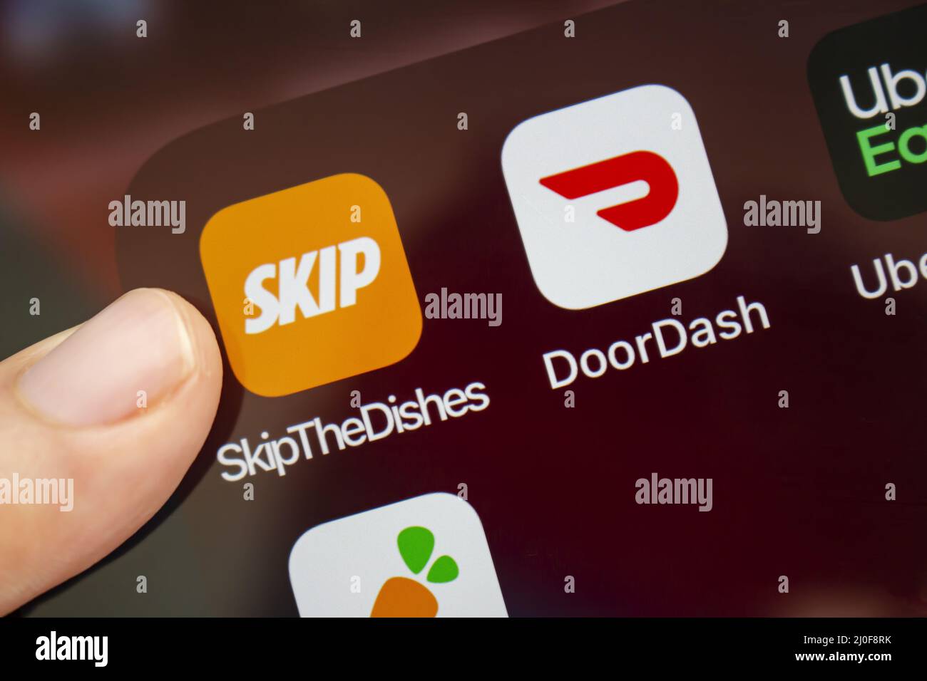 Calgary, Alberta, Kanada. August 2020. Eine Person, die die App „Skip the Dishes“ mit ihrem neuen Logo verwenden wird. Stockfoto