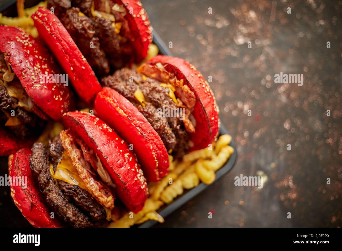 Set aus vier hausgemachten riesigen Doppel becon Käse Burger. Serviert mit pommes frites auf Holzbrett. Stockfoto