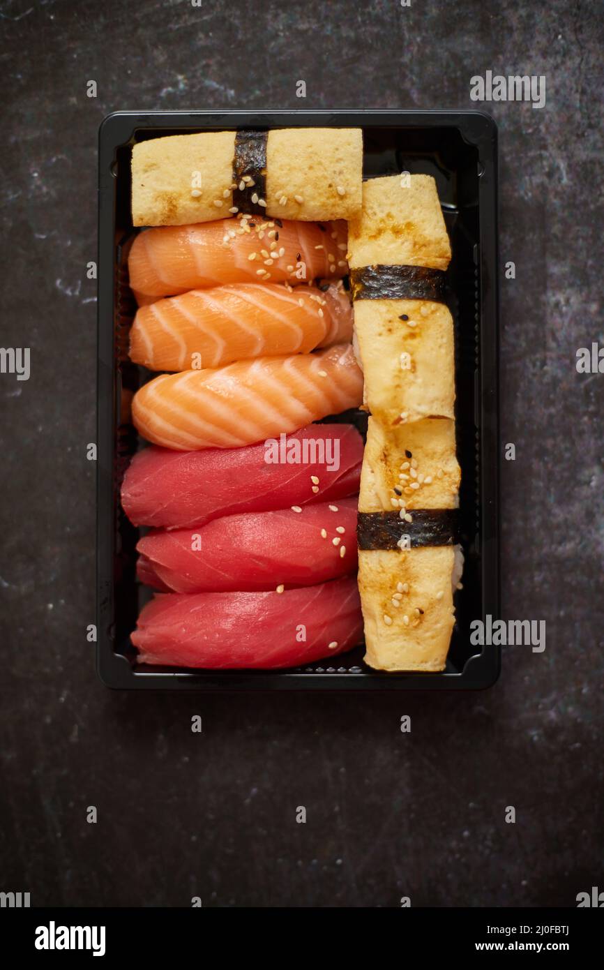 Nigiri Sushi-Set in Plastikbehälter bereit für die Lieferung zum Mitnehmen. Nahaufnahme der Lunchbox zum Mitnehmen Stockfoto