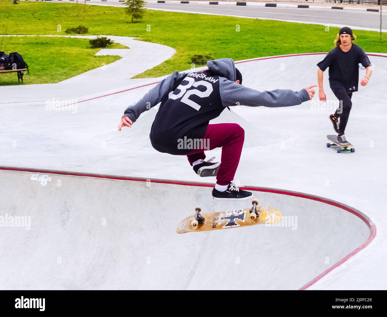 Sotschi, Russland - 26. Dezember 2019. Guy führt Sprung mit einem Skateboard Flip in einem Skatepark Stockfoto