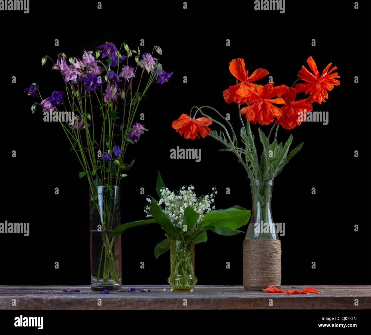 Bouquet von roten Mohnblumen, ein Bouquet von weißen Lilien des Tals und ein Bouquet von Blumen Glocken in gl Stockfoto