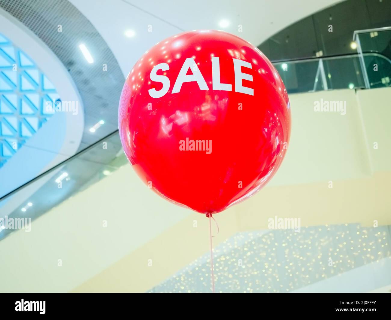 Leuchtend rote Heißluftballon mit weißen Schriftzug Verkauf in Das Einkaufszentrum Stockfoto
