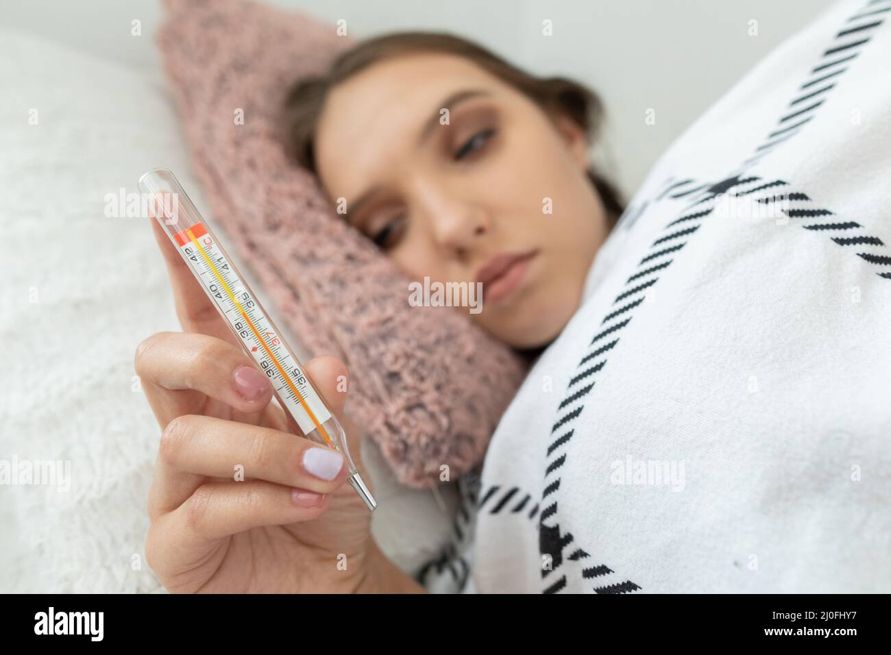 Der Teenager überprüfte ihre Temperatur und stellte fest, dass ihr Fieber hoch war. Stockfoto