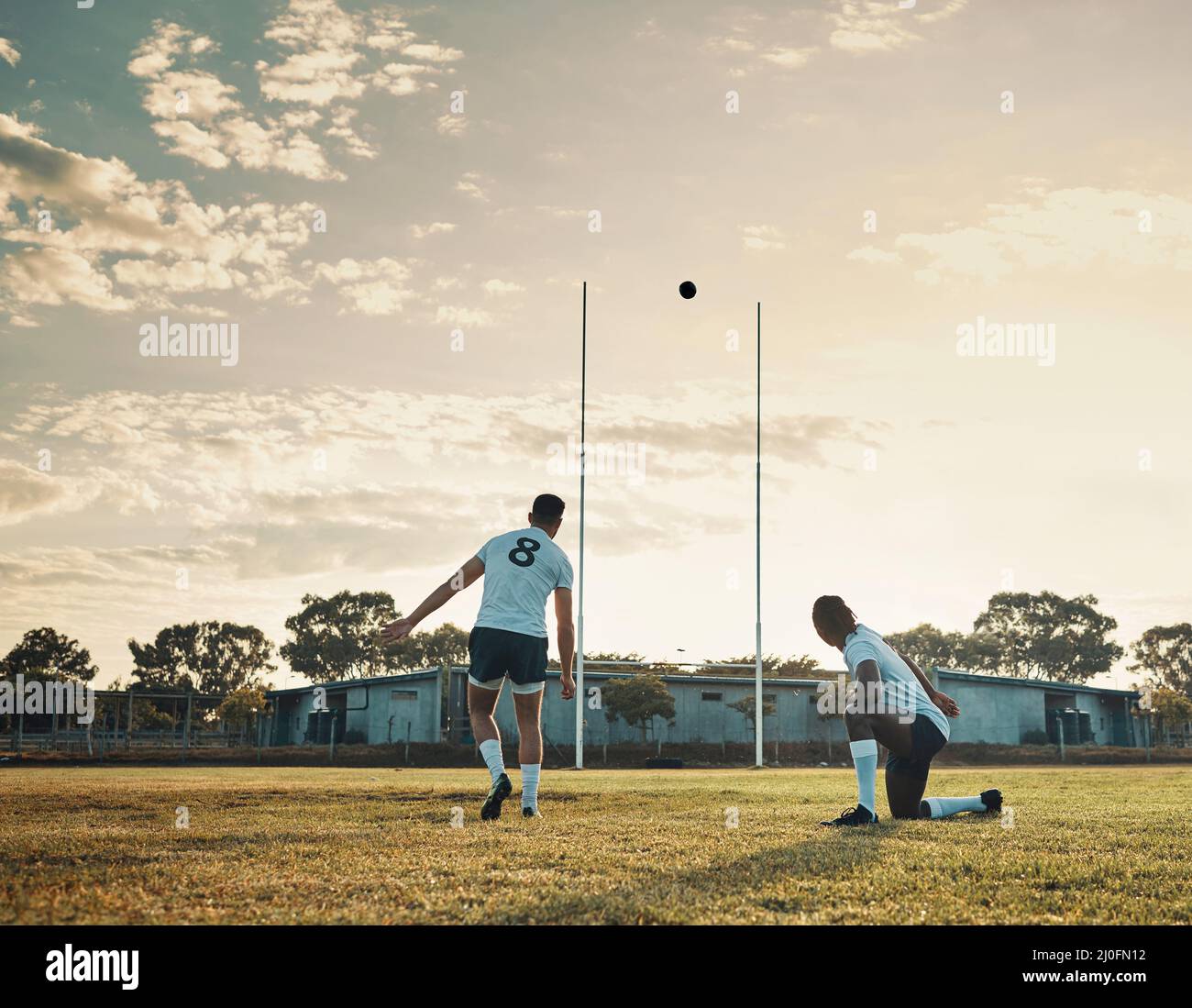 Das war ein Meisterstoß. Ganzkörperschuss von zwei jungen Rugby-Spielern, die tagsüber gemeinsam auf dem Feld trainieren. Stockfoto