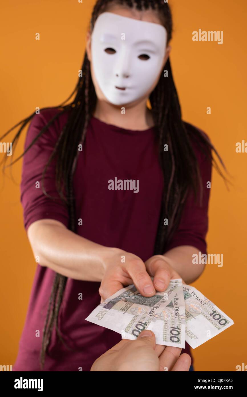 Eine männliche Hand greift nach Papierrechnungen, die von einer anonymen jungen Frau gegeben wurden. Eine isolierte Figur auf einer einfarbigen orangefarbenen Farbe. Stockfoto