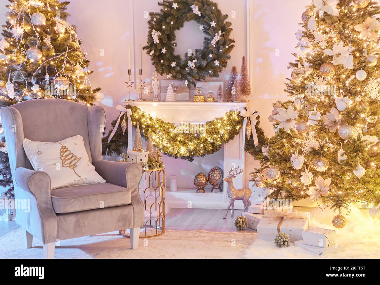 Weihnachtliches Interieurkonzept. Mit Kamin, Sessel, Kiefer, eingewickelte Geschenke, Lichter Stockfoto