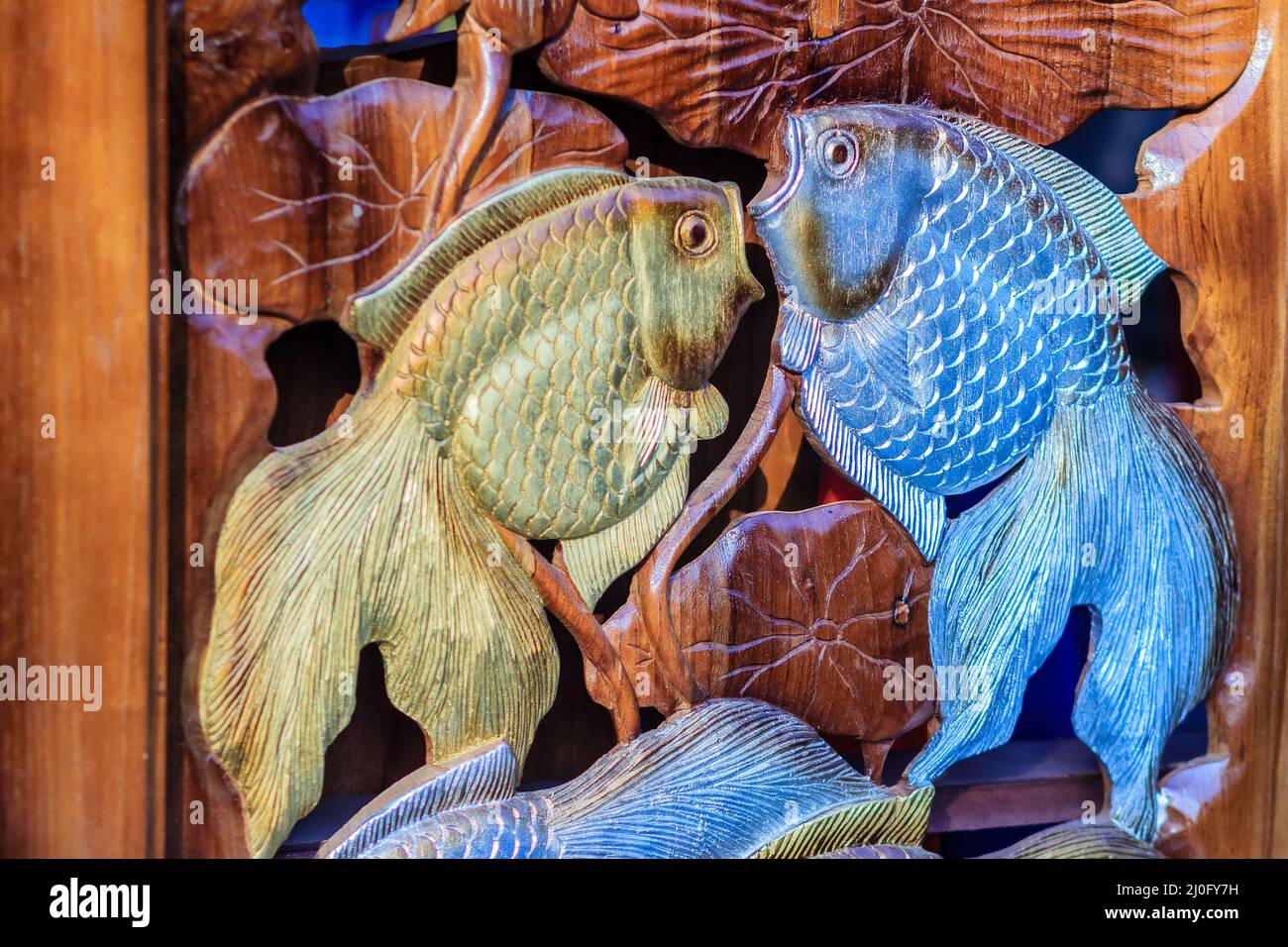Schöne Holzschnitzerei von goldenen Silberfischen. Antike Kunst Handgefertigte Möbel, die goldene Silberfische im Holz schnitzeln. Gold Stockfoto