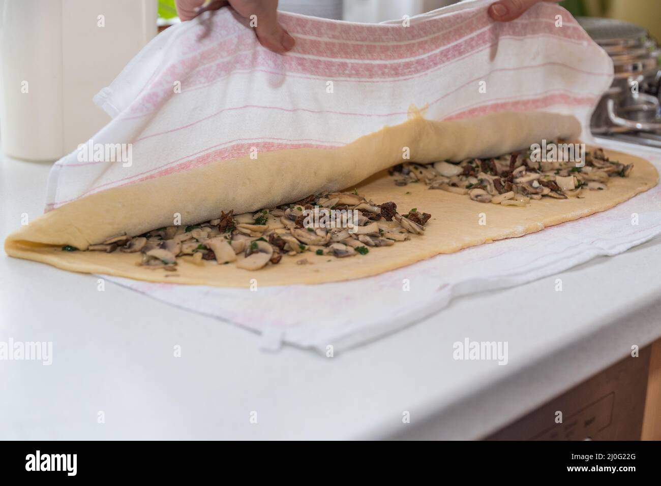 Zusammenrollender Kartoffelteig mit Pilzfüllung aus nächster Nähe kochen Stockfoto