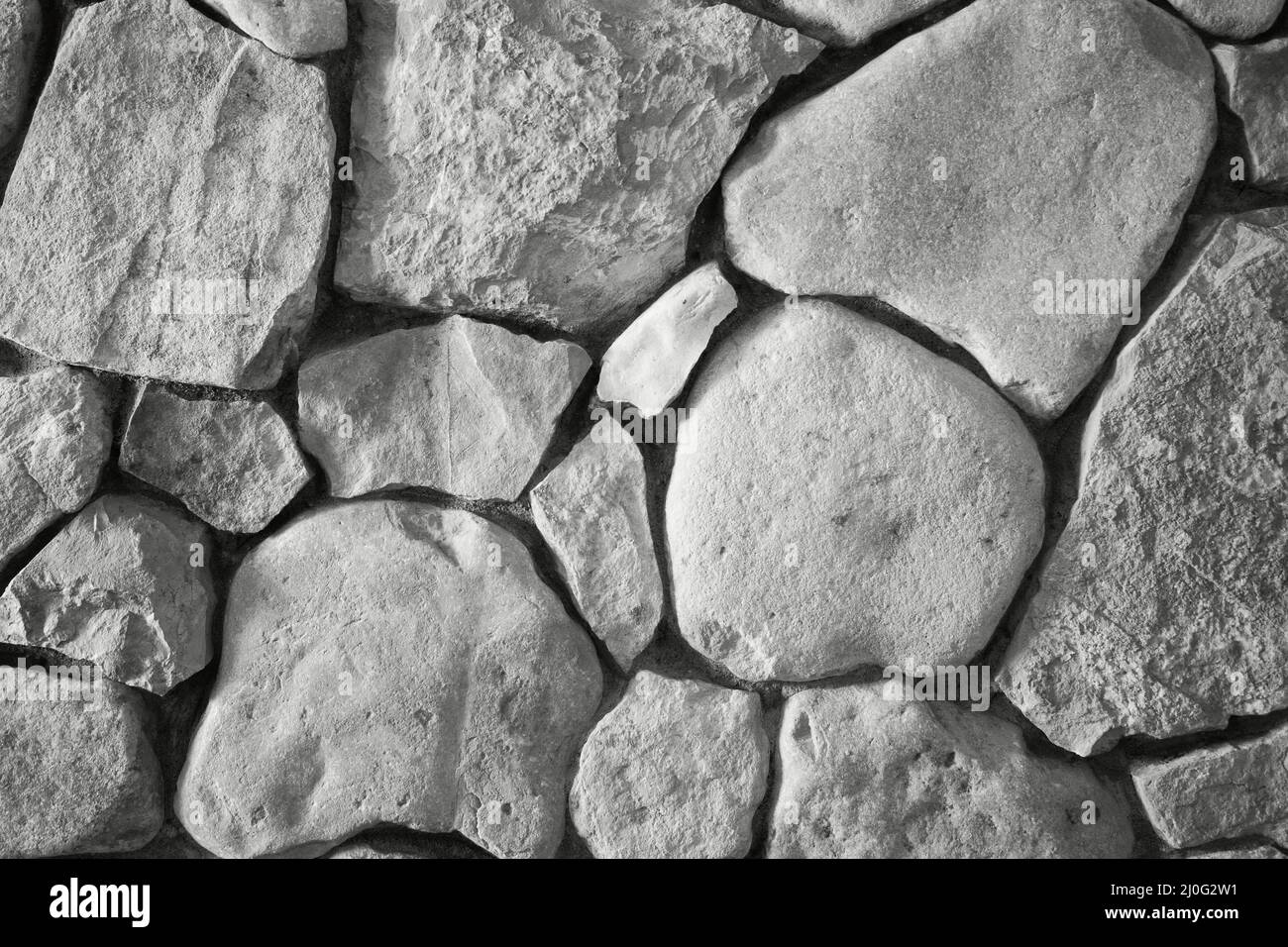 Hintergrund die Wand, die von einem Kalkstein in schwarz und weiß ausgelegt ist Stockfoto