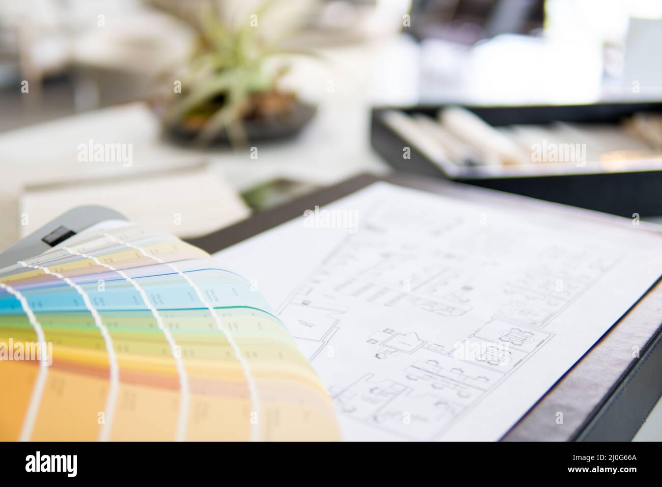 Der Arbeitstisch des Innenarchitekten, ein architektonischer Plan des Hauses, eine Farbpalette. Stockfoto